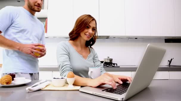 Mujer mostrando a su pareja algo en el ordenador portátil — Vídeo de stock