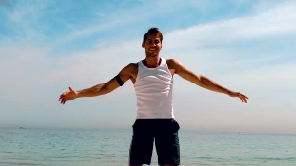 Мужчина делает прыжки с трамплина на пляже — стоковое видео