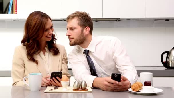 Par som visar varandra sina telefoner på frukost — Stockvideo