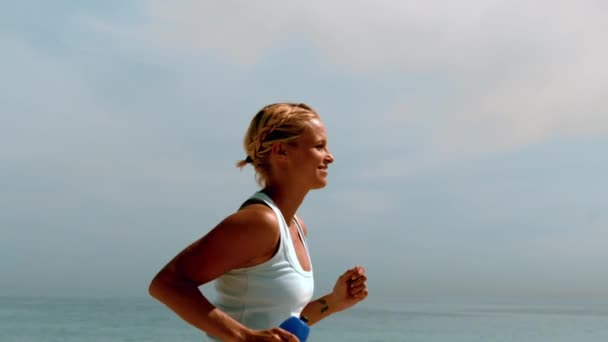 Sportswoman jogging attraverso spiaggia — Video Stock