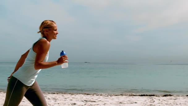 Спортсменка біжить на пляжі — стокове відео