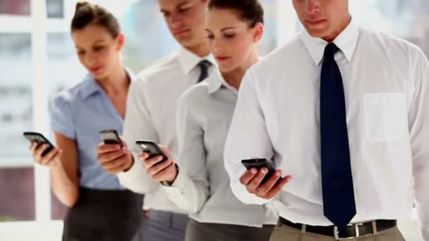 Business people standing with smartphones — Stock Video