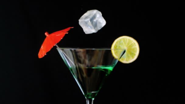 Glace tombant dans un cocktail vert — Video