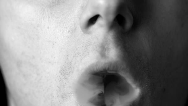 Man blowing smoke rings in black and white — Stock Video