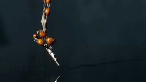 Розарійний бісер падає на чорну поверхню — стокове відео