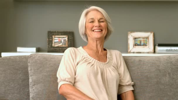 Retired woman smiling on couch — Stock Video