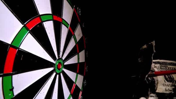 Red dart with a dollar note hitting dart board — Stock Video