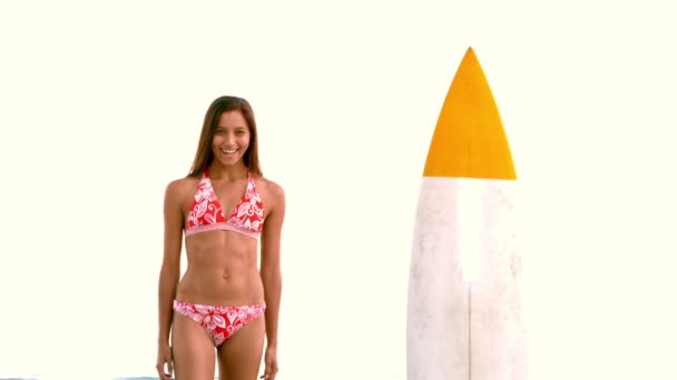 Woman jumping next to surfboard — Stock Video