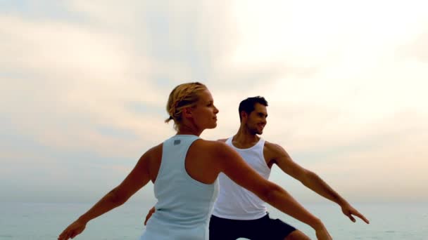 男人和女人做瑜伽在海滩上 — 图库视频影像