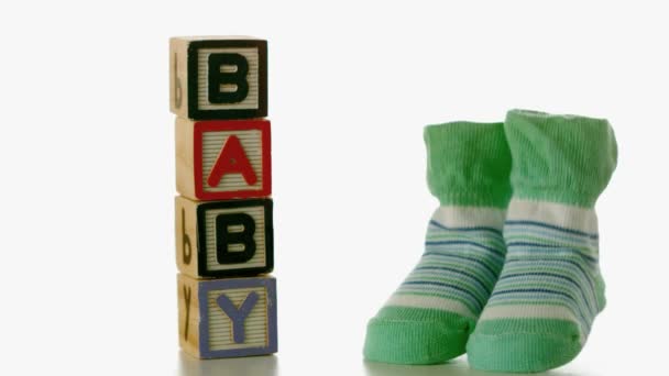Green slippers falling besides baby blocks — Stock Video