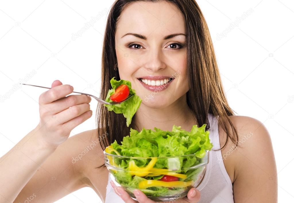 Beautiful young girl eats salad