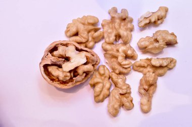 Olgun ceviz çekirdekleri beyazın üzerinde yatar.