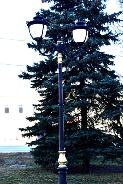 Straatlamp in vintage vorm op de achtergrond van een kerstboom. — Stockfoto