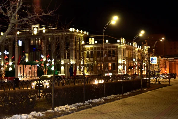 Geceleri şehir. Bir sokak ve ışıklarla aydınlatılmış büyük bir bina.. — Stok fotoğraf