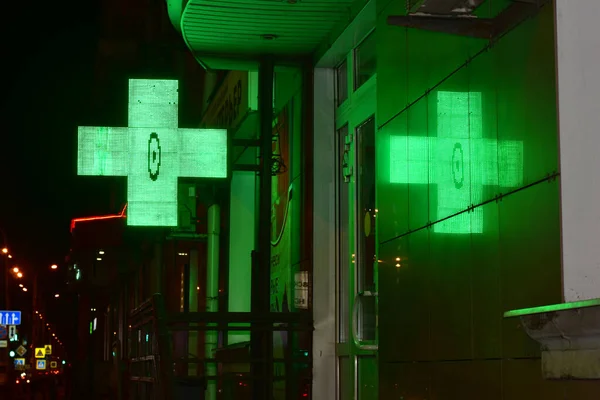 タイル張りの壁に緑のライトで燃焼薬局のクロスの反射 — ストック写真