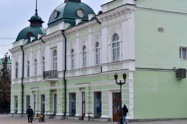 Resim, çatısı örümceklerle dekore edilmiş ve yeşile boyanmış güzel yüzlü bir binayı gösteriyor..