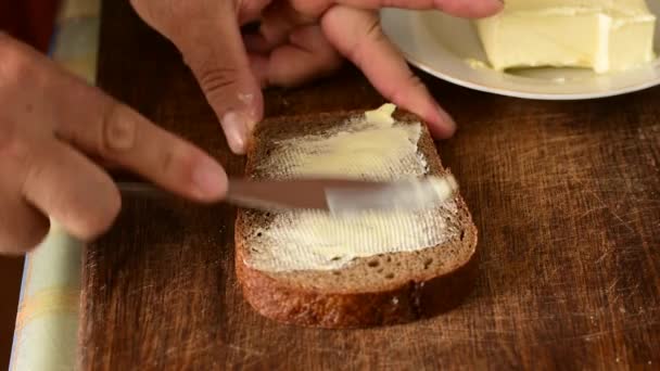 Een Man Gebruikt Een Breed Mes Boter Een Stuk Brood — Stockvideo