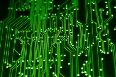 Resim yeşil bir elektronik devre kartının ve elektrik hatlarının yakın çekimini gösteriyor..