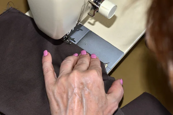 图为坐在缝纫机旁工作的女裁缝的手 — 图库照片
