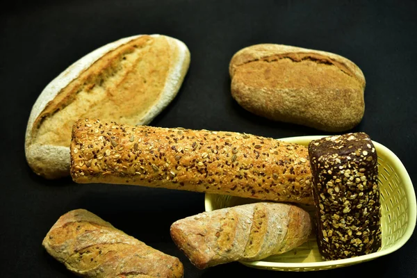 Several Loaves Bread Various Shapes Lie Chaotically Dark Background — Foto Stock