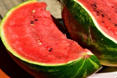 The picture shows a ripe watermelon cut into large pieces.