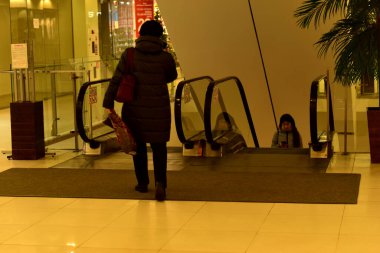 Mağazadaki alıcı yürüyen merdivene iniyor. 11:25: 20221. Tambov. Rusya.