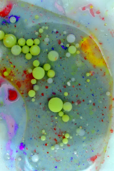 Mavi arkaplanda çok renkli sabun köpükleri tarafından oluşturulan doku deseni.