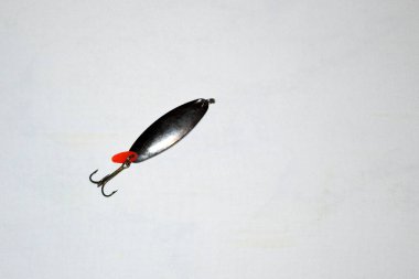 Bir metal kaşık beyaz bir masada yatıyor..