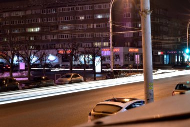 Editör imajı. 02 numara. 16 yaşında. 2020 yılı. - Rusya. Tambov. Şehir caddesinin at arabalarından biri ve yol boyunca geçen arabaların farları tarafından bırakılan düz beyaz çizgiler..