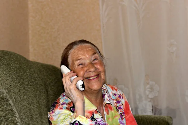 Пожилая Леди Улыбается Разговаривая Телефону Находясь Дома — стоковое фото