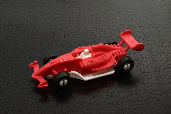 Picture Racing Car Childrens Toy Red Athlete Stands Dark One — Fotografia de Stock