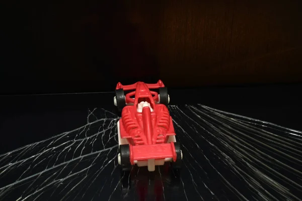 写真ではレース用の赤い車が暗い道を走っています — ストック写真