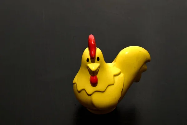 Zdjęciu Zabawka Dla Dzieci Żółty Kurczak Stojący Ciemnej Powierzchni — Zdjęcie stockowe