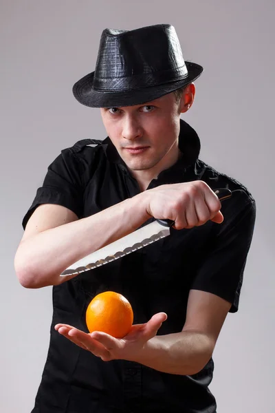 Porträtt av man med kniv och orange — Stockfoto