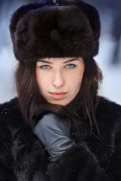 Young beautiful woman in fur hat in winter forest — Stock Photo, Image