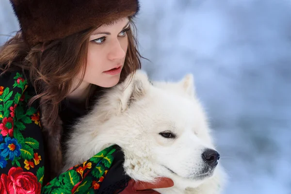 Young beaytiful woman in fur hats in winter forest with dog Samo — Stock Photo, Image