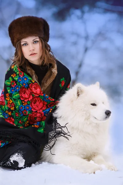 Young beaytiful woman in fur hats in winter forest with dog Samo — Stock Photo, Image
