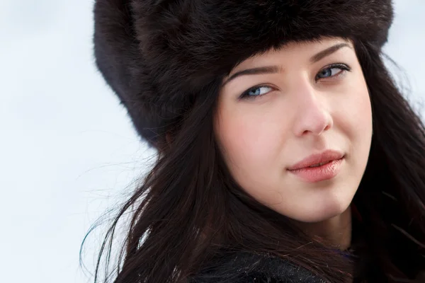 Young beautiful women in fur hat in winter forest — Stock Photo, Image