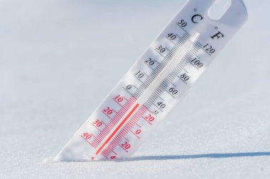 Termometre karın üzerinde yatar ve mavi gökyüzünde soğuk havada negatif bir sıcaklık gösterir. Düşük hava ve ortam sıcaklıklarına sahip meteorolojik koşullar. İklim değişikliği ve küresel ısınma