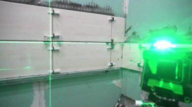 Yeni binadaki duvarların onarımı ve inşaatı. İnşaat seviyesi ve lazer seviyesi kullanarak duvar kiremitleri döşeniyor. Evde tadilat var. Lazer kullanarak hesaplamalar ve ölçümler yap