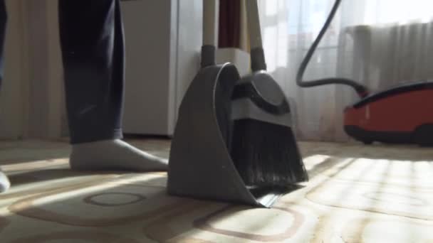 用扫帚把地板上的垃圾清理干净 用扫帚把灰尘和污垢扫进垃圾箱 在家里用扫帚把地毯扫清 — 图库视频影像