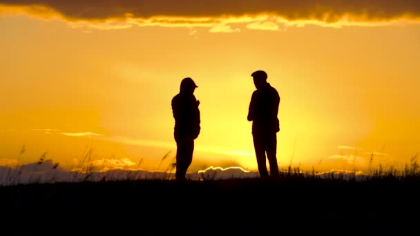 Zwei Silhouetten Von Männern Gespräch Bei Sonnenuntergang Oder Sonnenaufgang Mit — Stockvideo