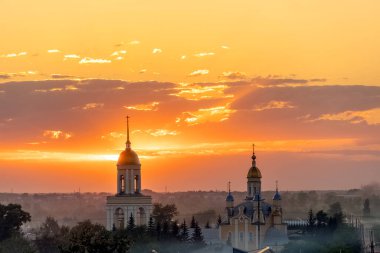 Kilisede Ortodoks haçları olan altın kubbeler. Tapınak ya da akşam güneşinin arka planında altın gökyüzü olan katedral. Günbatımında bulutlu yalnız bir kilise. Altın saat, ufuk çizgisi, ufuk çizgisi.