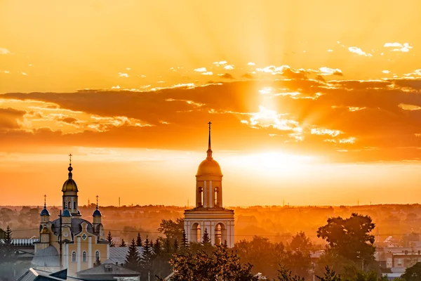 Golden domes with Orthodox crosses on the church.Temple or cathedral on the background of an evening sunset with a golden sky. A lonely church at dusk with sunset clouds.Golden Hour,skyline,horizon
