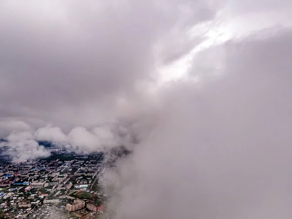 Flying through thick clouds. Rain clouds in the sky. Cumulus clouds, meteorology and climate studies.Video of the city from the height of clouds, aerial photography.Quadcopter,drone
