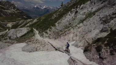 Kar kanyonunda dağ bisikletçisinin üstünde hava görüntüsü.