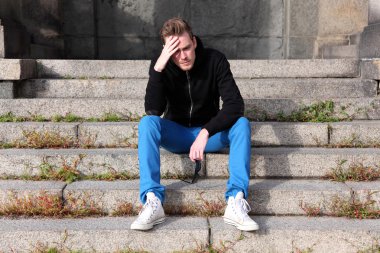 Dış görünüm oturan adam endişeli