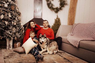 Anne, baba ve Noel ağacı arka plan üzerinde bir köpek Husky ile küçük çocuk