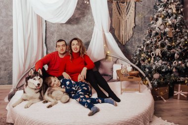 Anne, baba ve Noel ağacı arka plan üzerinde bir köpek Husky ile küçük çocuk