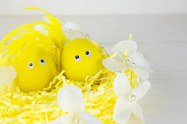 Dekorativ korg med gula ägg dekorerade med fjädrar i solen — Stockfoto